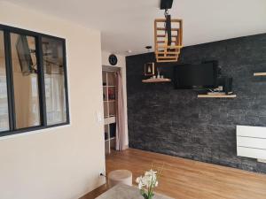 a living room with a tv on a brick wall at Apartment with pool included in Agde