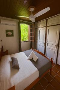 Un dormitorio con una gran cama blanca con ventana. en Villa Ti Flè, en Saint-François