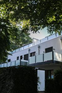 ein weißes Gebäude mit einem Balkon darauf in der Unterkunft Naemi Premium Apartment Hannover in Langenhagen