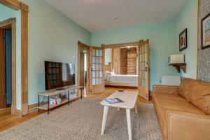 a living room with a couch and a tv at 1 Mi to Xcel Energy Center Home with Yard and Garden in Saint Paul