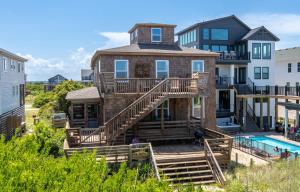 een huis met een terras en een zwembad bij Crow's Nest K0380 in Nags Head