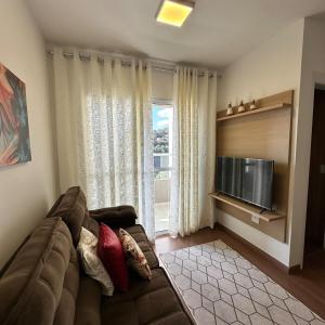 a living room with a couch and a flat screen tv at Plano 22 Prime Loft in Extrema