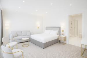 a white bedroom with a bed and a couch at The Hadley Hotel in New Barnet +32 photos