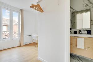 a kitchen with white walls and a table and a window at Residence Raspail - Montreuil in Montreuil
