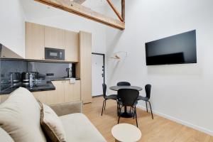 a living room with a couch and a table at Residence Raspail - Montreuil in Montreuil