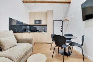 a living room with a couch and a table and chairs at Residence Raspail - Montreuil in Montreuil +97 photos