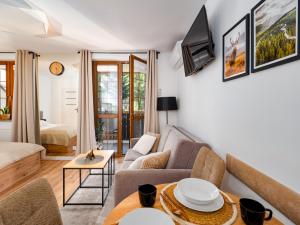 a living room with a couch and a tv at Apartament Królewski w centrum Nad Łomnicą 15 in Karpacz