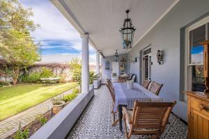 a porch with a table and chairs and a view at Blue Bell in Hermanus