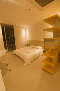 a bedroom with a bed and a book shelf at Distrito 90 luxury suites in Barranquilla +15 photos
