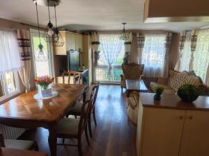 a kitchen and living room with a wooden table and chairs at Agroturystyka u Kozdryka in Leśna
