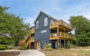 a large blue house with a deck at Climate Change in Duck