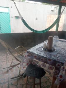 a table and a chair with a coffee cup on it at Quarto - Room de hóspedes da Menina Maricotinha 2 in Manaus