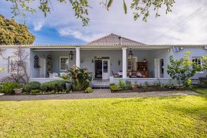 a white house with a green yard at Blue Bell in Hermanus