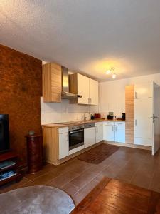 ロイタッシュにあるApartment Nalaの白いキャビネットとテレビのある空のキッチン