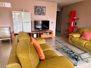 Una sala de estar con un sofá y un televisor. en Gran apartamento con piscina en Denia, en Denia