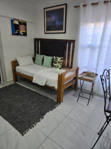 a bedroom with a bed and a table in a room at Oasiselfcatering guest house in Kimberley