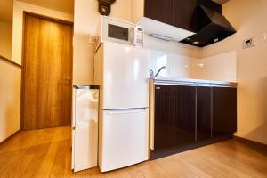 a white refrigerator in a kitchen with a microwave at 宿や 陣 in Kyoto