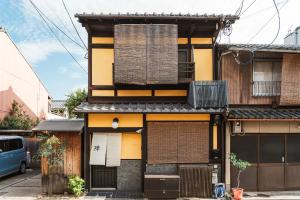 a yellow and black building on a street at 宿や 陣 in Kyoto
