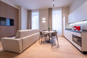 a living room with a couch and a table with chairs at Oriana Homèl Milano in Milan