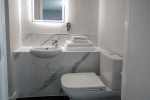 a white bathroom with a sink and a toilet at Best Western Premier Suites Hotel & Spa Liverpool-Knowsley in Knowsley