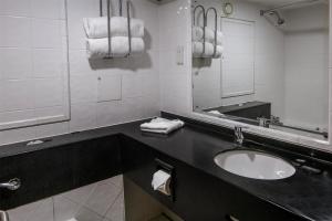 a bathroom with a sink and a mirror and towels at Best Western Premier Suites Hotel & Spa Liverpool-Knowsley in Knowsley +67 photos