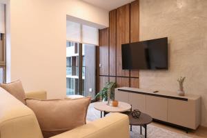 uma sala de estar com um sofá e uma TV na parede em The Modern by Wynwood House em Lima mais 13 fotografias