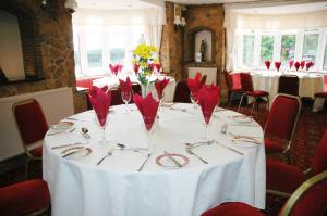 una mesa con servilletas rojas y gafas. en The Down Inn, en Bridgnorth