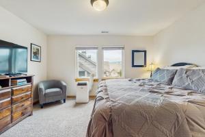 ein Schlafzimmer mit einem Bett, einem Fernseher und einem Stuhl in der Unterkunft Ridgeview Retreat in Ronald