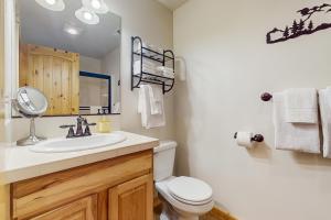 ein Badezimmer mit Toilette, Waschbecken und Spiegel in der Unterkunft Ridgeview Retreat in Ronald + 18 Fotos