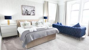 a bedroom with a bed and a blue couch at Kenavara House in Oban