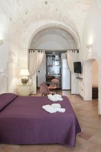 Un dormitorio con una cama morada con toallas encima. en CASA FLAMì 5, en Ostuni