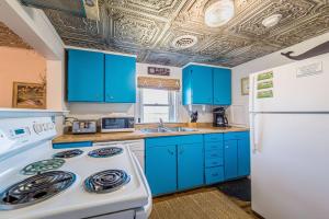 une cuisine avec des armoires bleues et un réfrigérateur blanc dans l'établissement Deja Blue, à Kill Devil Hills