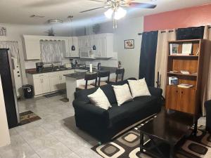 a living room with a couch and a kitchen at Wallflower Place in Savannah