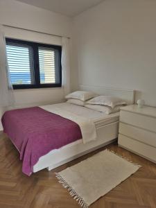 a bedroom with a large bed and a window at Apartments with sea view in Kožino