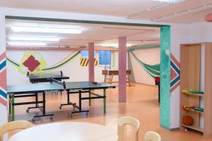 a room with two ping pong tables and a hammock at Jugendherberge Ulm in Ulm