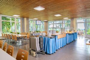 a large room with tables and chairs and windows at Jugendherberge Ulm in Ulm