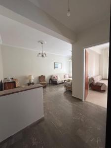 a living room with white walls and concrete floors at Marina's house in Preveza