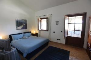 una camera con un letto blu e una finestra di Agriturismo Lapone a Orvieto