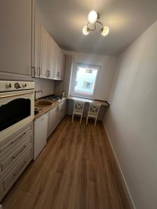 a kitchen with white cabinets and a table and a window at AAS Vibe in Alba Iulia