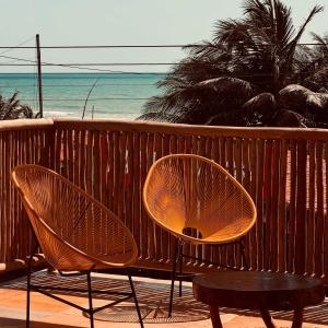 two chairs and a table on a balcony with the beach at Casa Tartaruga Emboaca Trairí in Trairi +34 photos