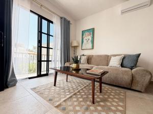 a living room with a couch and a table at Casa DOS21 Boutique Apartments Playa Sur in Mazatlán