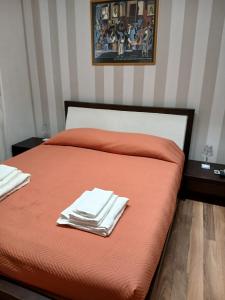 a bed with orange sheets and white towels on it at Gianicolo House in Rome