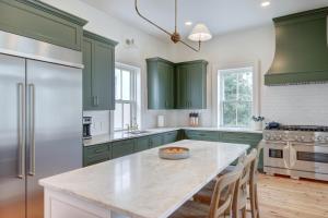 eine Küche mit grünen Schränken und einem Tisch mit Stühlen in der Unterkunft The 200 South St | King Ste 20 in Charlottesville