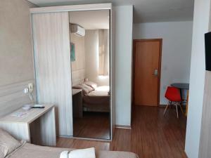 espejo grande en una habitación con dormitorio en Flats da Júnia no Paris Residence, en Lagoa Santa