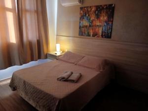 Una cama con dos toallas encima en un dormitorio. en Flats da Júnia no Paris Residence, en Lagoa Santa