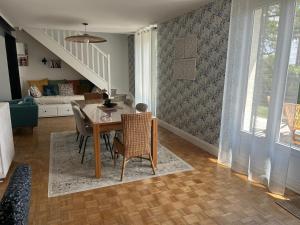 a dining room with a table and chairs and a living room at La résidence du domaine Apremont in Apremont
