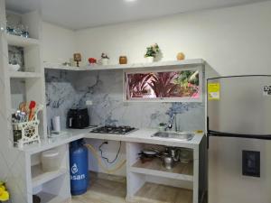 a small kitchen with a sink and a refrigerator at Kasa Soffi in Moñitos