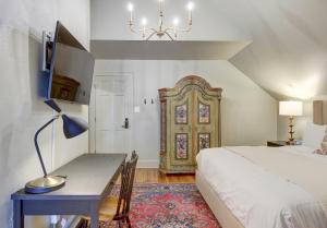 a bedroom with a bed and a desk and a door at The 200 South St - King Rm 11 in Charlottesville +25 photos