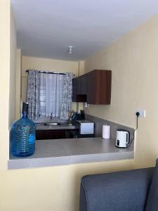 een keuken met een aanrecht met een fles water op het aanrecht bij The R&M Escapes in Kisumu