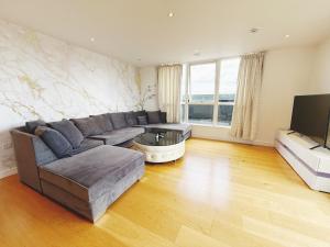 a living room with a couch and a tv at Fast WiFi, Free Netflix 2 Bedroom Penthouse with Large Balcony in Slough
